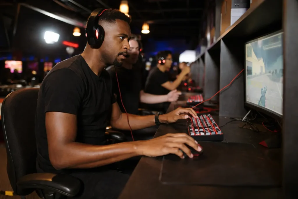 Professional gamer playing a PC game with a headset at a gaming station